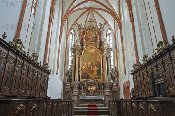 Magnificently designed church altar with rich wood carving and large painting in the background, St.Stephan's parish church in Tulln Lower Austria Austria