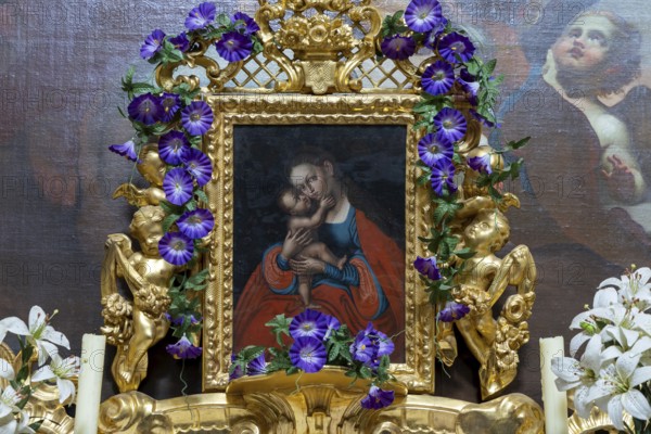 Medieval religious painting in a richly decorated golden frame with flowers and angels, Minoritenkirche Tulln Lower Austria Austria