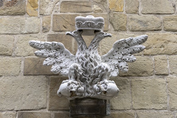 Stone relief of a crowned eagle, symmetrically and artistically embedded in a wall, St.Stephan's parish church in Tulln Lower Austria Austria