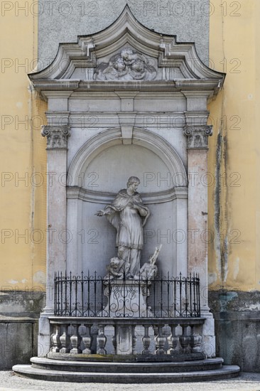 Baroque statue of a saint in a niche on a church wall, surrounded by decorative stone architecture, parish church St.Stephan Tulln Lower Austria Austria