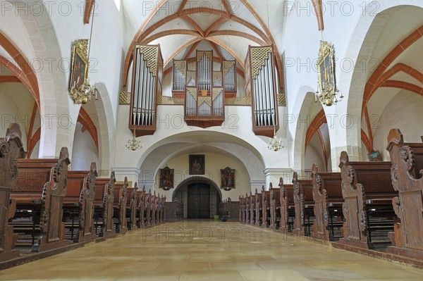 Interior of a church with detailed wooden benches and an impressive organ on the ceiling, St.Stephan parish church in Tulln Lower Austria Austria