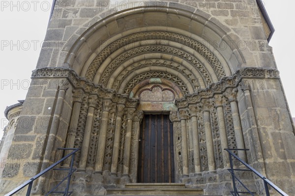 Romanesque stone door, ornate decoration and massive arches, staircases to the right and left, St.Stephan's parish church in Tulln Lower Austria Austria