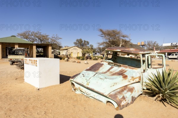 Solitaire's car graveyard in Namibia - 27 August, 2025: features rusted vintage cars near small desert buildings, set against dunes and mountains, capturing desert charm and isolation
