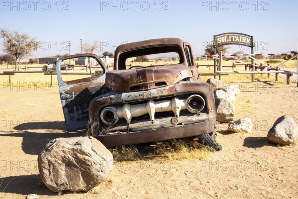 Solitaire's car graveyard in Namibia 27 August, 2025: features rusted vintage cars near small desert buildings, set against dunes and mountains, capturing desert charm and isolation