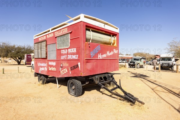 Solitaire's car graveyard in Namibia - 27 August, 2025: features rusted vintage cars near small desert buildings, set against dunes and mountains, capturing desert charm and isolation