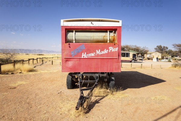 Solitaire's car graveyard in Namibia - 27 August, 2025: features rusted vintage cars near small desert buildings, set against dunes and mountains, capturing desert charm and isolation