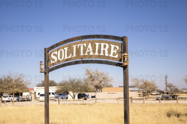 The remote desert settlement of Solitaire in Namibia - 27 August, 2025: features a sign displaying the town's name, set against golden sand dunes and rugged mountains