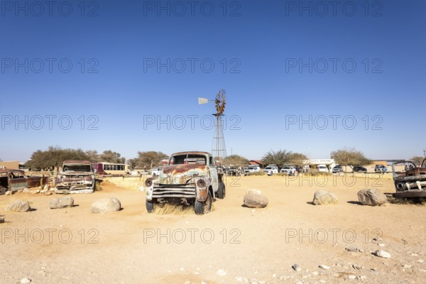Solitaire's car graveyard in Namibia - 27 August, 2025: features rusted vintage cars near small desert buildings, set against dunes and mountains, capturing desert charm and isolation