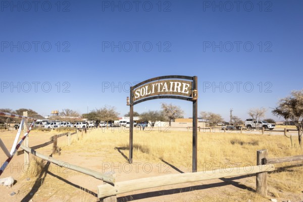 The remote desert settlement of Solitaire in Namibia 27 August, 2025: features a sign displaying the town's name, set against golden sand dunes and rugged mountains