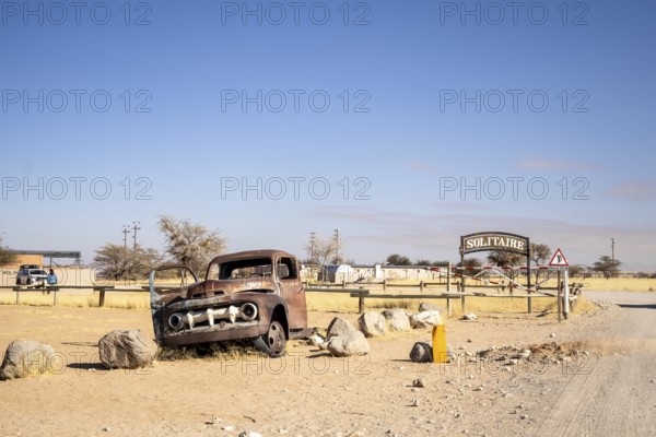Solitaire's car graveyard in Namibia - 27 August, 2025: features rusted vintage cars near small desert buildings, set against dunes and mountains, capturing desert charm and isolation