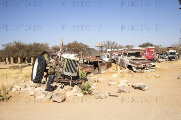 Solitaire's car graveyard in Namibia 27 August, 2025: features rusted vintage cars near small desert buildings, set against dunes and mountains, capturing desert charm and isolation