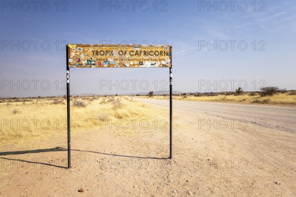 Namibia- 25 August, 2025: Road sign marking the Tropic of Capricorn in Namibia's dry, sandy landscape under a bright sky, with an isolated road leading to the horizon