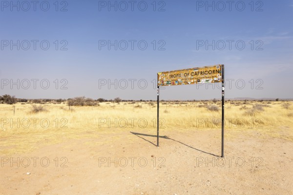Namibia- 25 August, 2025: Road sign marking the Tropic of Capricorn in Namibia's dry, sandy landscape under a bright sky, with an isolated road leading to the horizon