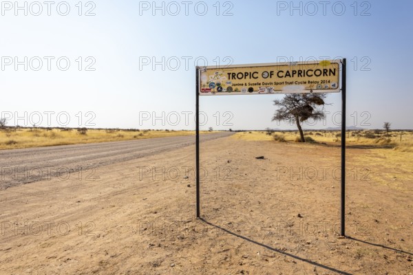 Namibia- 25 August, 2025: Road sign marking the Tropic of Capricorn in Namibia's dry, sandy landscape under a bright sky, with an isolated road leading to the horizon