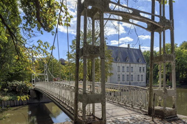 Suspension bridge in park of Kasteel Cortewalle, 15th century moated castle at Beveren in summer, Waasland, East Flanders, Belgium