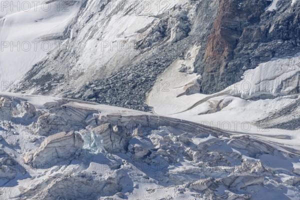The mountainous landscape reveals impressive glaciers with ice formations and gleaming reflections in the morning light. Details of rocky outcrops add to the natural beauty. Gorner Glacier, Zermatt, Valais, Alps, Swiss