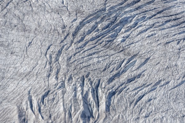 Crevices mark the surface of the glacier. The landscape is illuminated by daylight, highlighting the structure and colour of the ice. Gorner Glacier, Zermatt, Valais, Alps, Swiss
