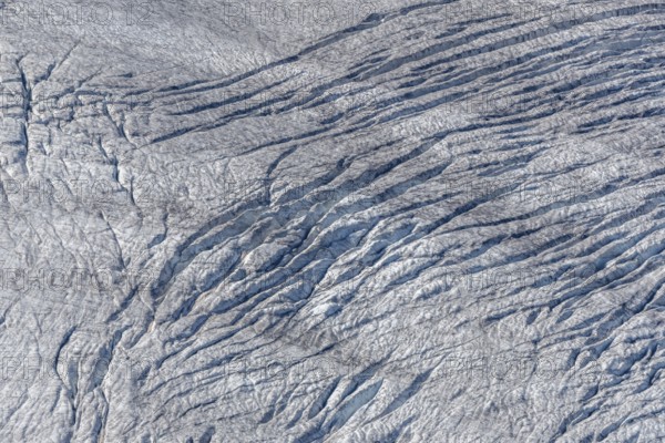 Crevices mark the surface of the glacier. The landscape is illuminated by daylight, highlighting the structure and colour of the ice. Gorner Glacier, Zermatt, Valais, Alps, Swiss