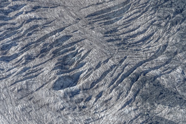 Crevices mark the surface of the glacier. The landscape is illuminated by daylight, highlighting the structure and colour of the ice. Gorner Glacier, Zermatt, Valais, Alps, Swiss