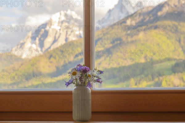 A vase with meadow flowers stands on the windowsill in the background the mountains of the Dolomites, San Candido, Val Pusteria, Sesto Dolomites, Dolomites, South Tyrol, Italy
