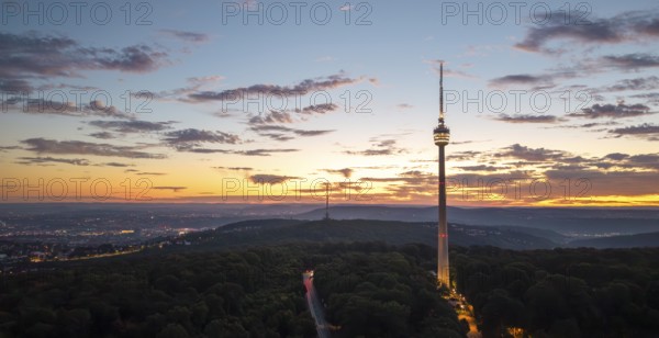 TV tower above wooded area at sunrise with dramatic sky, Stuttgart-Degerloch, Baden-Württemberg, Germany