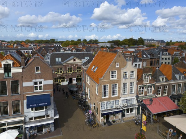 Urban street scene with shops, old buildings and bicycles under a cloudy sky, aerial view, houses at the market square, Delft, Province of South Holland, Zuid-Holland, Netherlands