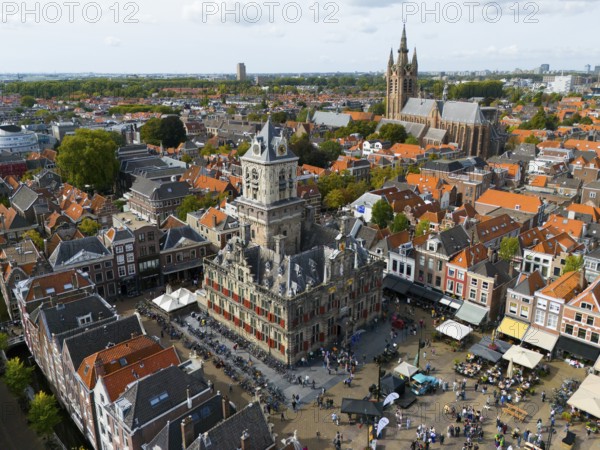 Town hall with tower, surrounded by historic buildings and lively market life, aerial view, town hall, on the right in the background Oude Kerk, Old Church, market square, Delft, province of South Holland, Zuid-Holland, Netherlands