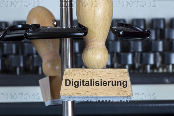 Stamp with added text DIGITALISATION in front of a typewriter