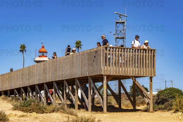 Tourists on the rocky coast of Ponta da Piedade, rugged coastal landscape, right next to Lagos city centre, in the west of the Algarve, Portugal