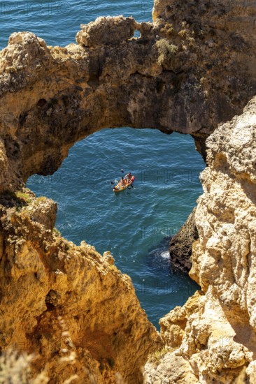 Excursion boats at the caves and rocky gates of the Ponta da Piedade rocky coast, rugged coastal landscape, right by the centre of Lagos, in the west of the Algarve, Portugal