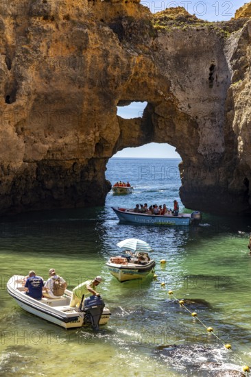 Excursion boats at the caves and rocky gates of the Ponta da Piedade rocky coast, rugged coastal landscape, right by the centre of Lagos, in the west of the Algarve, Portugal