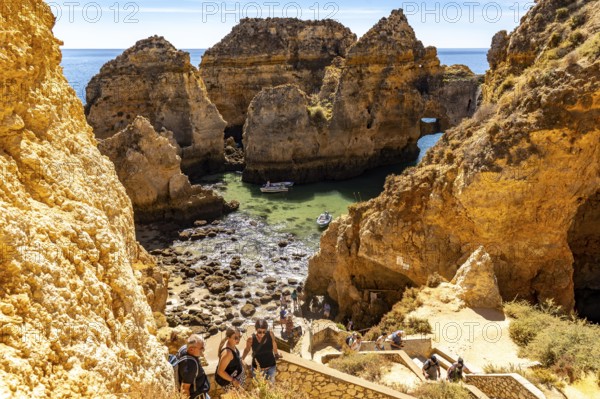 Excursion boats at the caves and rocky gates of the Ponta da Piedade rocky coast, rugged coastal landscape, right by the centre of Lagos, in the west of the Algarve, Portugal