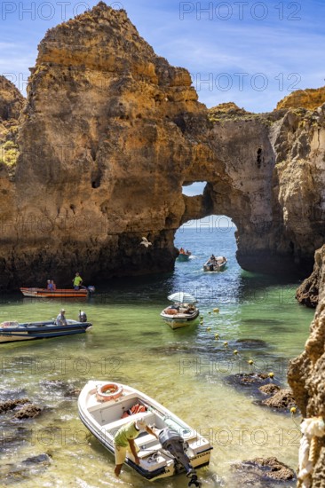 Excursion boats at the caves and rocky gates of the Ponta da Piedade rocky coast, rugged coastal landscape, right by the centre of Lagos, in the west of the Algarve, Portugal