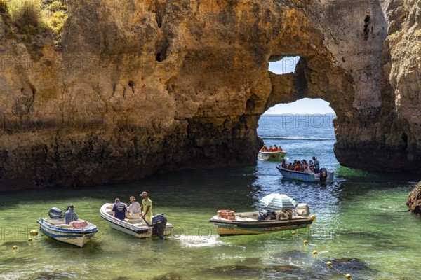 Excursion boats at the caves and rocky gates of the Ponta da Piedade rocky coast, rugged coastal landscape, right by the centre of Lagos, in the west of the Algarve, Portugal