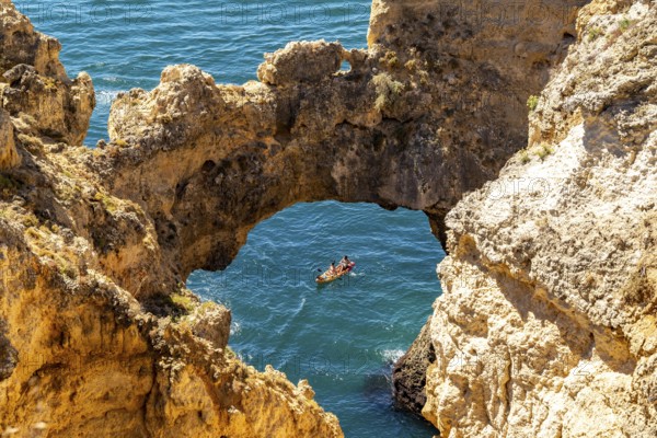 Excursion boats at the caves and rocky gates of the Ponta da Piedade rocky coast, rugged coastal landscape, right by the centre of Lagos, in the west of the Algarve, Portugal