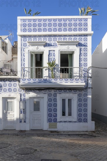 Facade of buildings decorated with tiles, azulejos, coloured tiles on facades, in Tavira, old town, in the east of the Algarve, Portugal