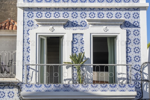 Facade of buildings decorated with tiles, azulejos, coloured tiles on facades, in Tavira, old town, in the east of the Algarve, Portugal