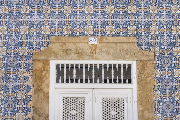 Facade of buildings decorated with tiles, azulejos, coloured tiles on facades, in Tavira, old town, in the east of the Algarve, Portugal