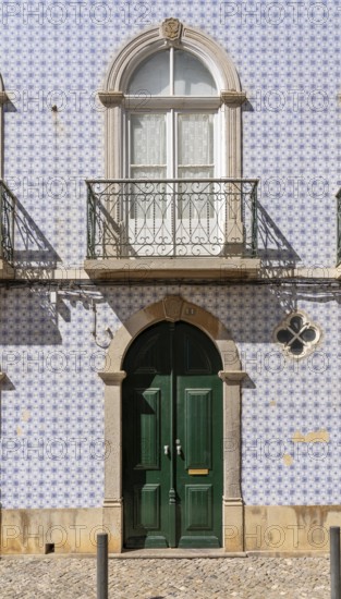 Facade of buildings decorated with tiles, azulejos, coloured tiles on facades, in Tavira, old town, in the east of the Algarve, Portugal