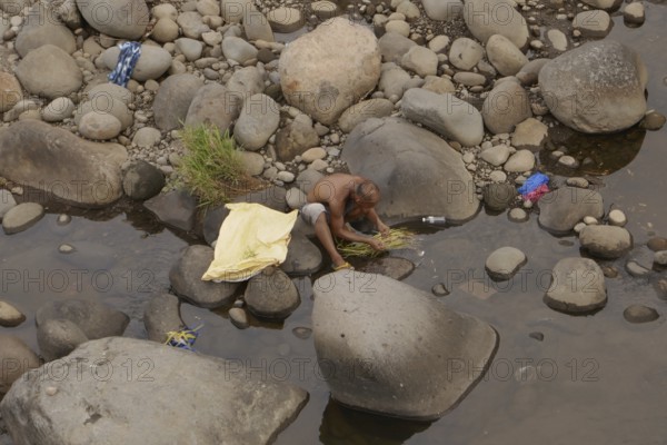 Man washing vegetables in the river, Negros Occidental, Philippines