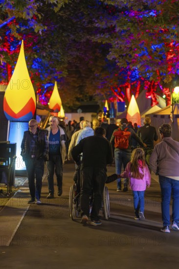 People at a colourful city festival at night with illuminated trees and stalls, Sindelfingen, district of Böblingen, Germany