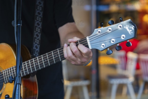 Close-up of a musician playing an acoustic guitar, Sindelfingen, Böblingen district, Germany