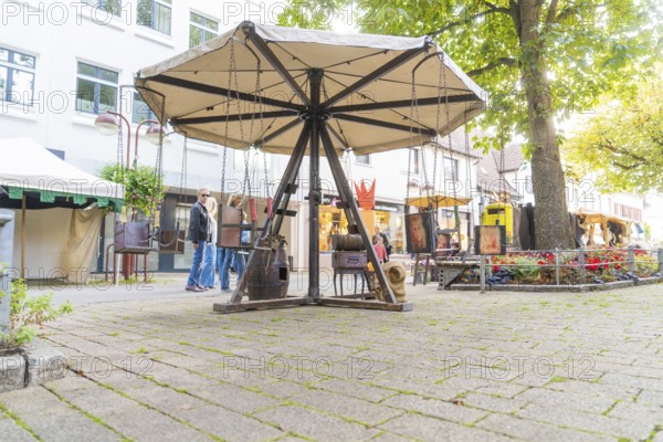 An empty, wooden carousel stands on a cobbled market square, Sindelfingen, Böblingen district, Germany