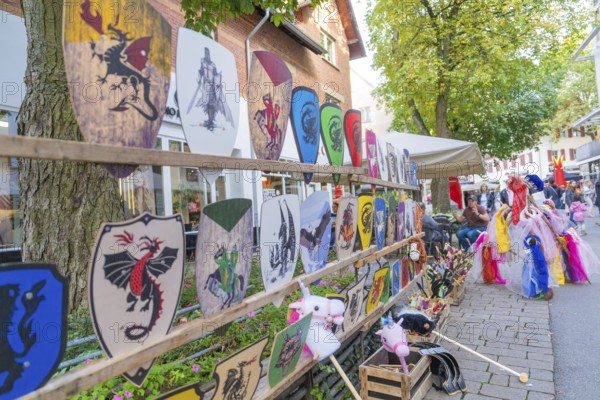 Various colourful coats of arms and children's toys on display at a market, Sindelfingen, Böblingen district, Germany