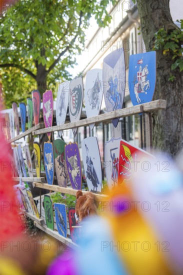 Several painted coats of arms are decoratively attached to a wooden fence, Sindelfingen, Böblingen district, Germany