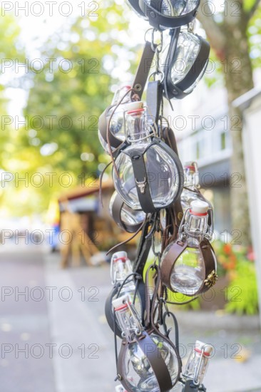 Leather-wrapped bottles hanging decoratively from a stall at a market, Sindelfingen, Böblingen district, Germany