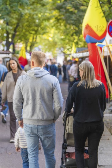 People walking along a crowded street surrounded by trees and autumn leaves, Sindelfingen, Böblingen district, Germany