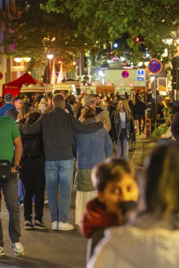 Large group of people at night in a busy urban environment with festive lighting, Sindelfingen, Böblingen district, Germany