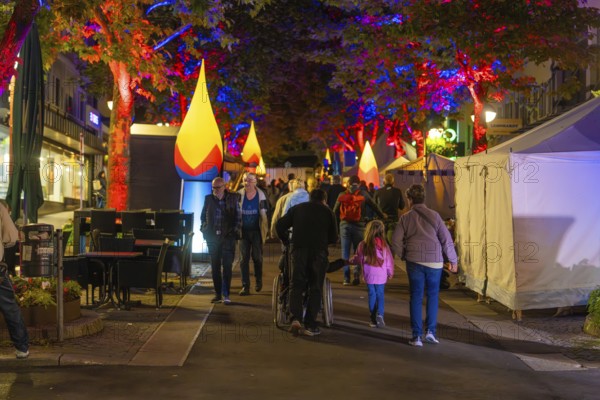 People strolling on a colourful, festive street at night with illuminated trees, Sindelfingen, Böblingen district, Germany