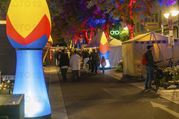 A busy city street at night, illuminated by colourful lamps and lights, Sindelfingen, Böblingen district, Germany
